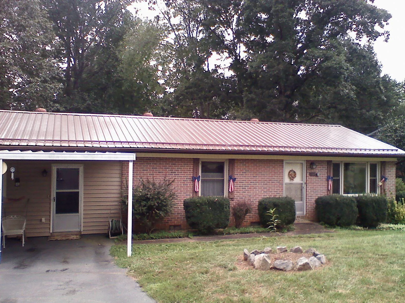 Bronze metal roof and carport on a brick ranch home — Roof Repair work by our crew in Cocoa Beach